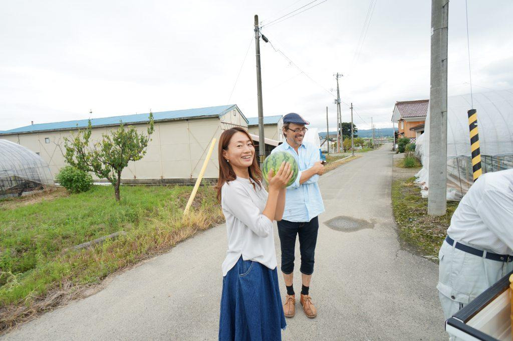 すいかを手に取る亜貴さん・リチャードさん